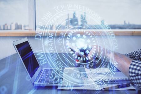 Double exposure of mans hand holding and using a digital device and data theme hologram drawing....