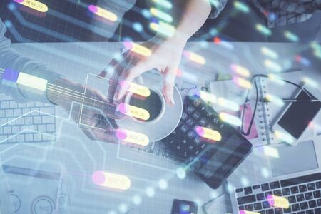 Double exposure of man and woman working together and data theme hologram drawing. Computer background. Top View.の写真素材