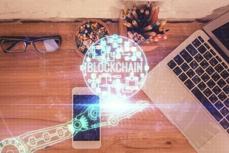 Double exposure of blockchain theme hologram over table with phone. Top view. Crypto technology concept.の写真素材
