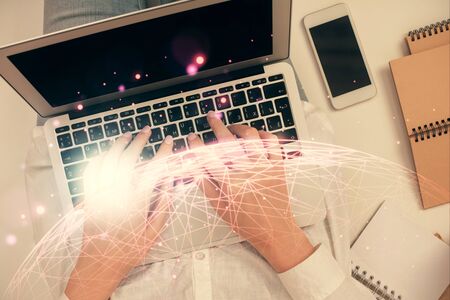 Double exposure of woman hands working on computer and social network theme hologram drawing. Top...