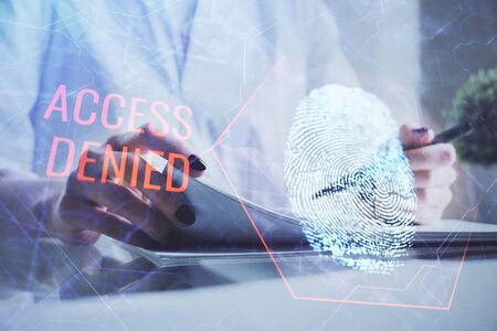 Blue fingerprint hologram over hands taking notes background. Concept of security. Double exposureの写真素材