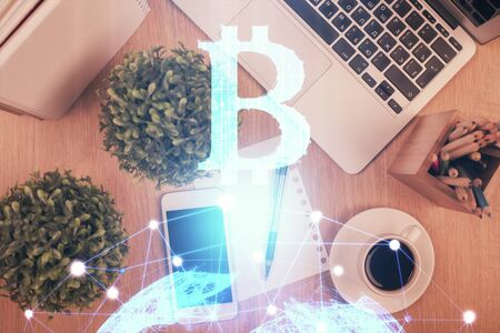 Double exposure of blockchain theme hologram over table with phone. Top view. Crypto technology...