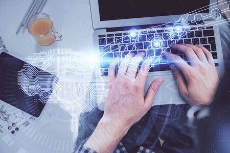 Double exposure of mans hands typing over computer keyboard and brain hologram drawing. Top view. Ai...