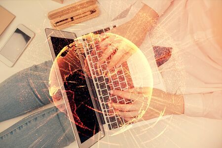 Double exposure of woman hands working on computer and social network theme hologram drawing. Top View. People connection concept.の写真素材
