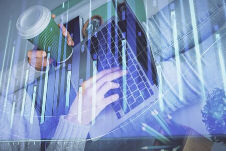 Double exposure of woman hands typing on computer and forex chart hologram drawing. Stock market invest concept.の写真素材