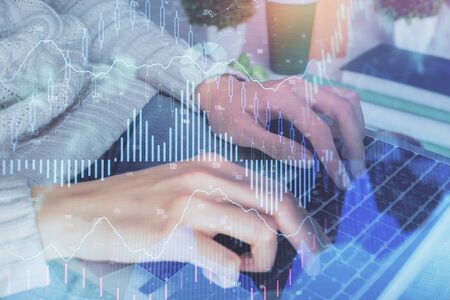 Double exposure of woman hands typing on computer and forex chart hologram drawing. Stock market invest concept.の写真素材
