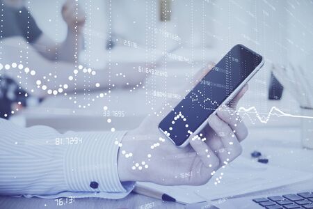 Double exposure of mans hand holding and using a digital device and data theme hologram drawing. Technology concept.の写真素材