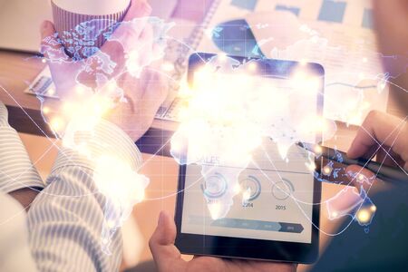 Double exposure of mans hands holding and using a phone and international business theme drawing.