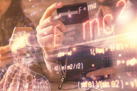 Double exposure of man and woman on-line shopping holding a credit card and formulas hologram drawing. Education E-commerce concept.の写真素材