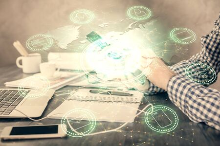 Double exposure of mans hands holding and using a phone and social network theme drawing.