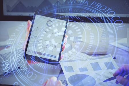 Double exposure of mans hand holding and using a digital device and data theme hologram drawing....