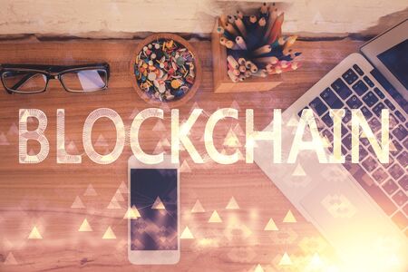 Double exposure of blockchain theme hologram over table with phone. Top view. Crypto technology...