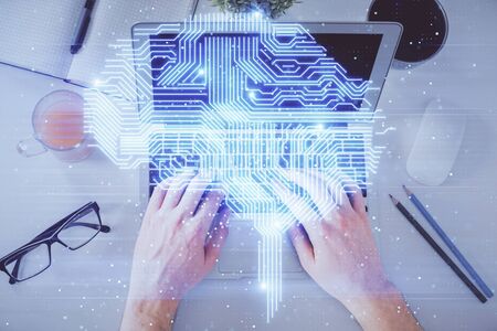 Double exposure of mans hands typing over computer keyboard and brain hologram drawing. Top view. Ai...