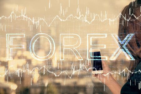 Double exposure of forex chart sketch hologram and woman holding and using a mobile device. Stock market concept.の写真素材