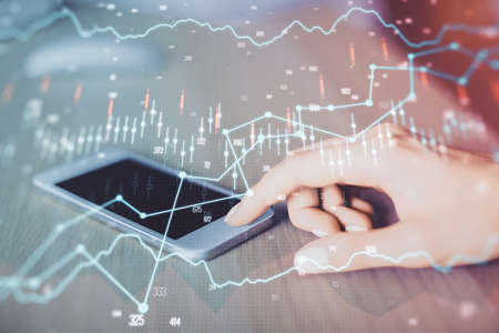 Double exposure of forex chart sketch hologram and woman holding and using a mobile device....