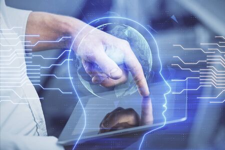 Double exposure of mans hand holding and using a digital device and brain hologram drawing. Data...