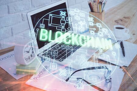 Double exposure of blockchain and crypto economy theme hologram and table with computer background....