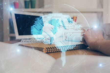 Multi exposure of writing hand on background with brain hologram. Concept of self learning.