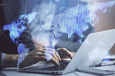 Multi exposure of businessman working on laptop on background. International business hologram in...