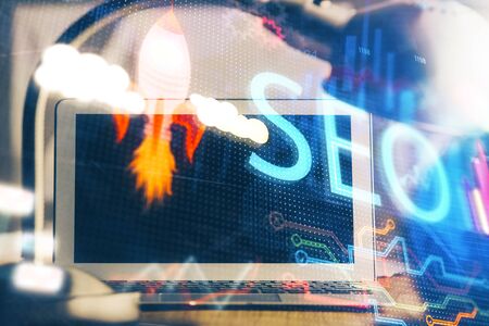 Double exposure of table with computer and seo drawing hologram. Search optimization concept.の写真素材