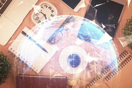 Double exposure of business theme hologram over desktop with phone. Top view. Mobile international trade connection concept.の写真素材