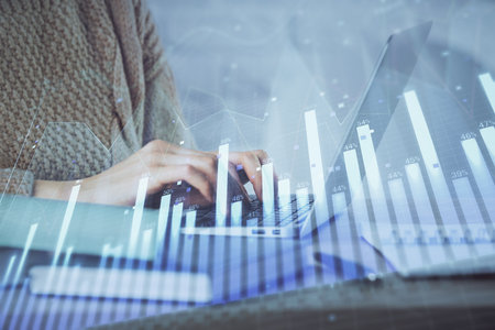 Double exposure of woman hands typing on computer and forex chart hologram drawing. Stock market analysis concept.の写真素材