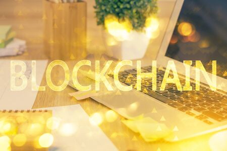 Multi exposure of blockchain theme hologram and table with computer background. Concept of bitcoin crypto currency.の写真素材