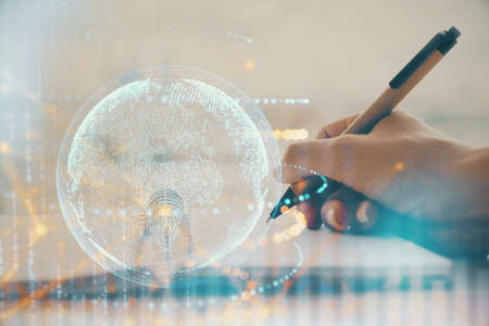Double exposure of hands making notes with world map hologram and data theme icons. Concept of...