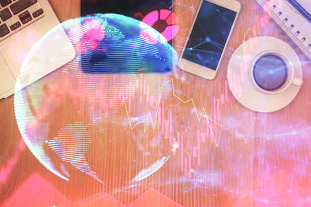 Double exposure of business theme hologram over desktop with phone. Top view. Mobile international...