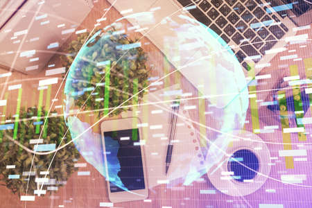 Double exposure of business theme hologram over desktop with phone. Top view. Mobile international...