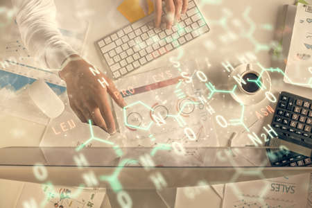 Double exposure of mans hands typing over computer keyboard and formula hologram drawing. Top view....