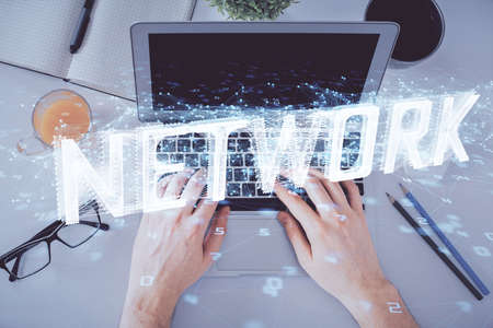 Multi exposure of mans hands typing over computer keyboard and data theme hologram drawing. Top view. Technology concept.の写真素材