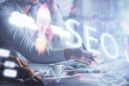 Double exposure of man and woman working together and seo drawing hologram. Technology concept. Computer background.の写真素材