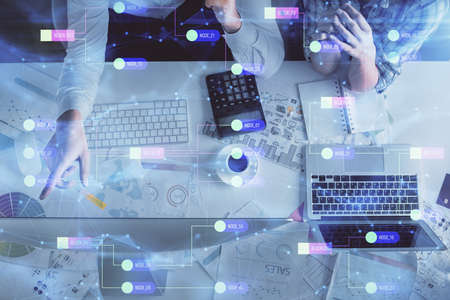Double exposure of man and woman working together and data theme hologram drawing. Computer...