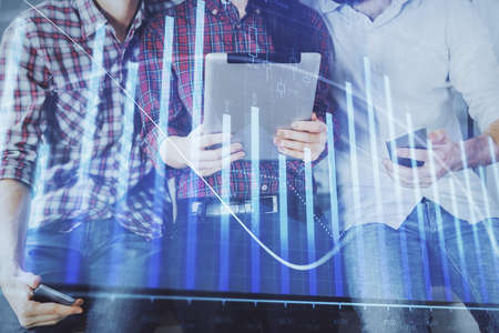 Double exposure of forex graph drawing and man and woman working together holding and using a mobile...