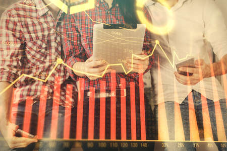 Double exposure of forex graph drawing and man and woman working together holding and using a mobile...