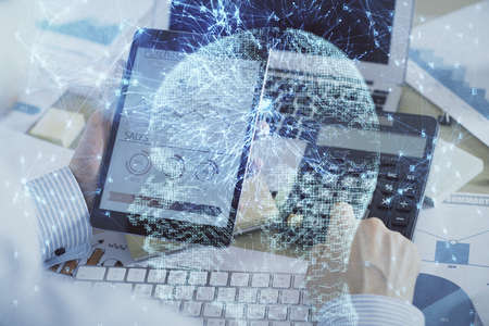 Double exposure of mans hand holding and using a digital device and brain hologram drawing. Data...
