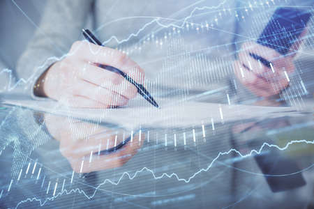 Double exposure of forex chart sketch hologram and woman holding and using a mobile device....
