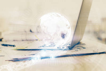 Double exposure of desktop with computer and world map hologram. International data network concept.