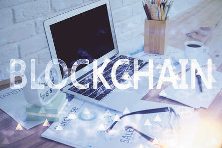 Double exposure of blockchain and crypto economy theme hologram and table with computer background....