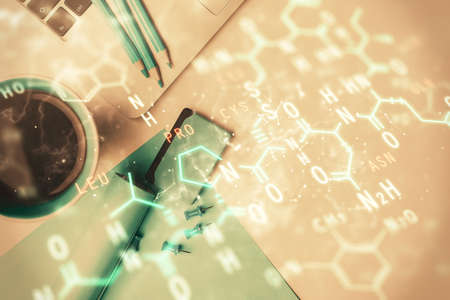 Physics and math theme hologram with formula drawings over computer on the desktop background. Top view. Multi exposure. Concept of education.の写真素材