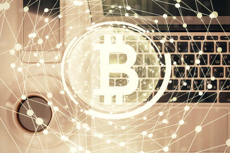 Blockchain theme hologram drawings over computer on the desktop background. Top view. Double...