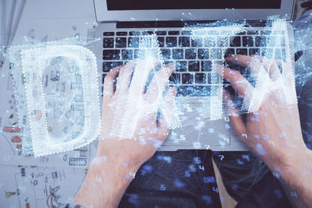Multi exposure of mans hands typing over computer keyboard and data theme hologram drawing. Top view. Technology concept.の写真素材