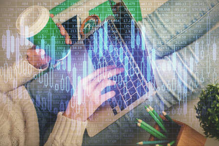Double exposure of woman hands typing on computer and forex chart hologram drawing. Stock market...