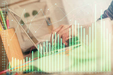 Double exposure of woman hands typing on computer and forex chart hologram drawing. Stock market...