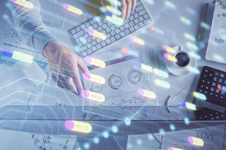 Double exposure of mans hands typing over computer keyboard and data theme hologram drawing. Top...