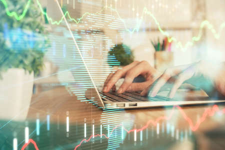 Double exposure of woman hands typing on computer and forex chart hologram drawing. Stock market...