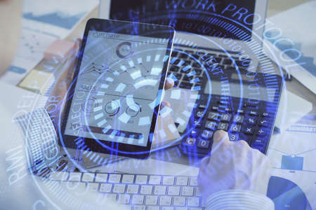 Double exposure of mans hand holding and using a digital device and data theme hologram drawing....