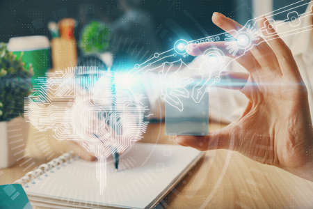 Multi exposure of writing hand on background with brain hologram. Concept of learning.