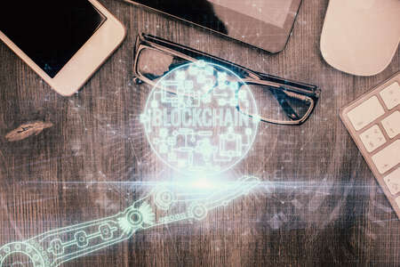 Double exposure of blockchain theme hologram over table with phone. Top view. Crypto technology concept.の写真素材